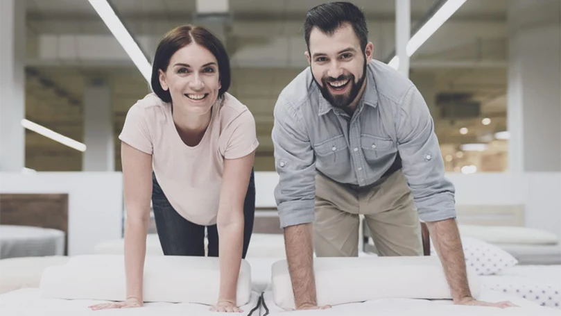 an image of a couple trying out a new mattress