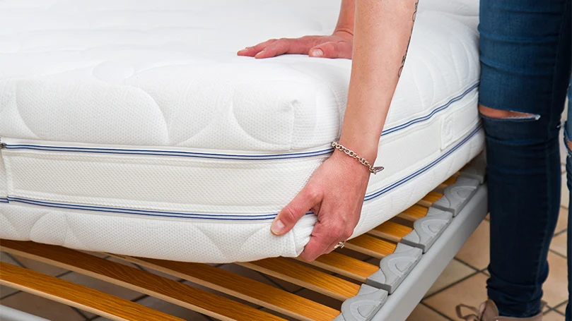 an image of a man inspecting a new mattress