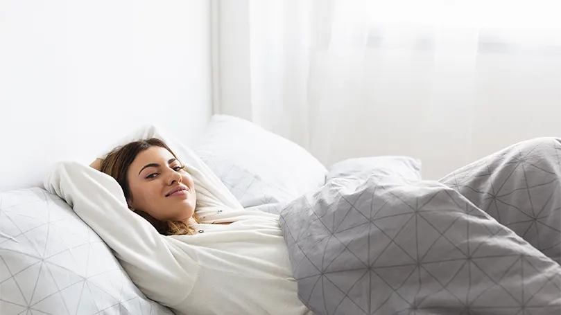 A relaxed woman in bed.