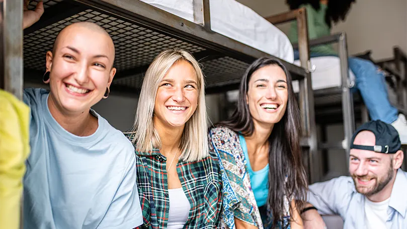 An image of adults sitting on loft & bunk beds.