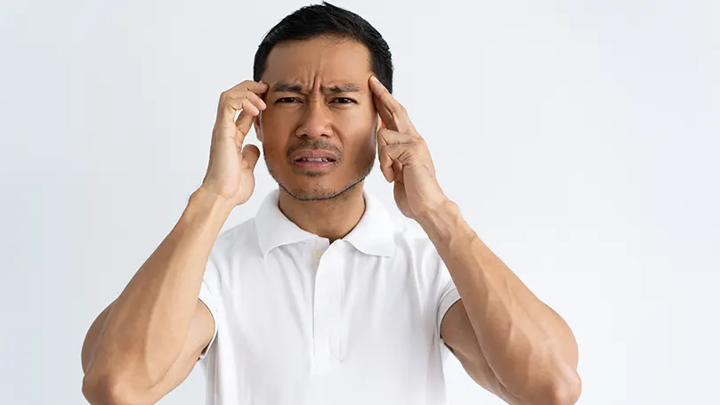 An image of a young man suffering from headache.