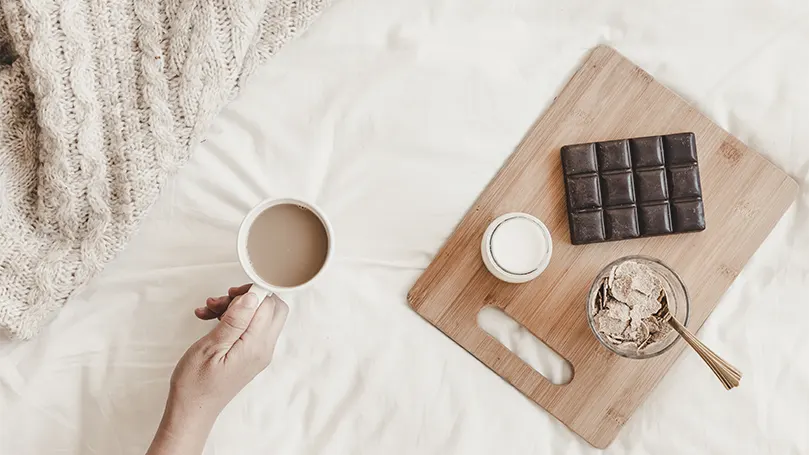 A hand holding a cup of hot chocolate.