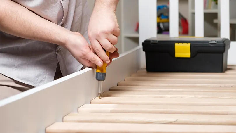 An image of a guy assembles solid slats.