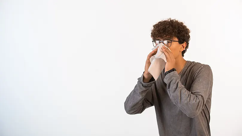 An image of a man blowing his nose.