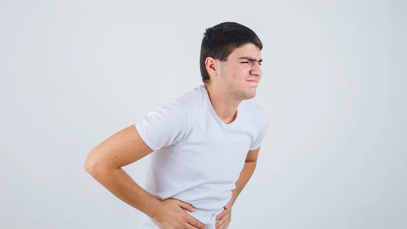 A man clenching his stomach in pain