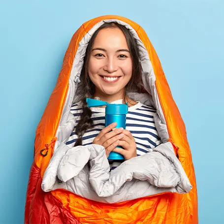 A woman in an orange sleeping bag