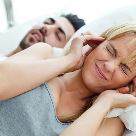 A man snoring next to a woman that can't sleep