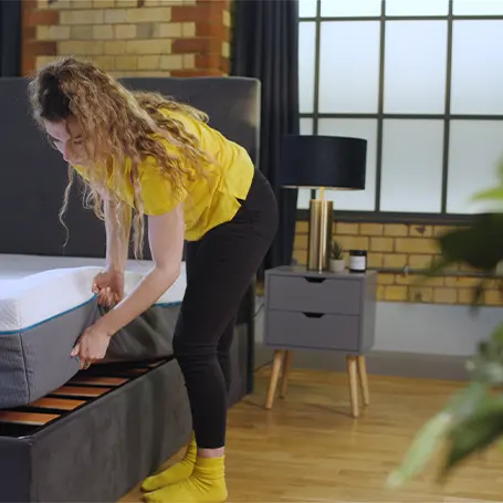 TSA reviewer lifting the Simba Hybrid Pro mattress